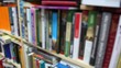 books on bookshelfs in bookshop, vertical panning, defocused