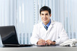 Successful doctor with laptop, at office