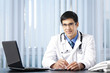 Successful doctor with laptop, at office