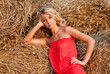 Beautiful blond young woman near haystack