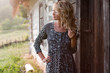 Beautiful blond woman near country house in the sunset light