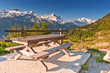 Picnic table and benches in Swiss Alps near mountain road.