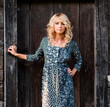 Beautiful barefoot blondie near old wooden house