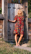 Beautiful blond young woman in the wooden gate