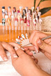 Nageldesignerin bearbeitet das Nagelbett eines Fingers