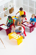 overhead of teacher helping preschool students in class