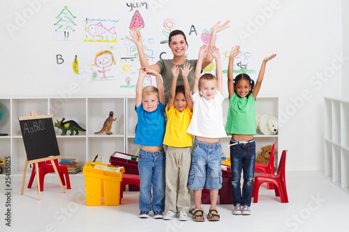 Photo: cheerful teacher and preschool kids in classroom cheerful teacher and preschool kids in classroom
