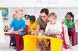 kindergarten teacher helping young students
