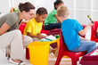 preschool teacher helping kids paint pictures