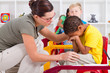 teacher comforting crying preschool boy
