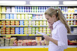 woman reading her shopping list in the supermarket woman reading her shopping list in the supermarket