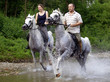 canvas print picture - Ein Mann und eine Frau reiten durch eine Fluss