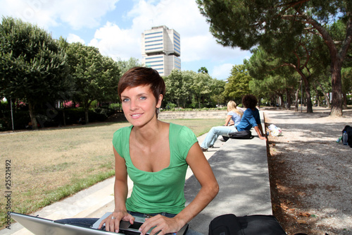 Photo: Student with laptop computer in college park Student with laptop computer in college park