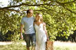A young couple carrying a picnic basket