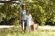 A young couple carrying a picnic basket