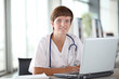 Foto : Closeup of beautiful nurse in front of laptop computer Closeup of beautiful nurse in front of laptop computer