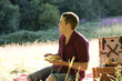 A young man having a picnic, laughing