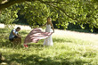 A young couple laying a picnic blanket on the grass