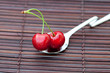 cherry in spoon on a bamboo mat cherry in spoon on a bamboo mat