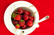 cup saucer spoon cherry and strawberry on a red background cup saucer spoon cherry and strawberry on a red background