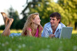 A couple relaxing in the park with a laptop A couple relaxing in the park with a laptop