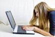 Young girl working with a laptop on the couch