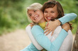 Closeup portrait of two happy female friends hugging outdoor