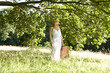 A young woman carrying a picnic basket, smiling
