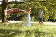 A young couple laying a picnic blanket on the grass