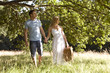 A young couple carrying a picnic basket