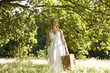 A young woman carrying a picnic basket