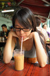 girl drinking a Hong Kong-style milk tea in Dai pai dong
