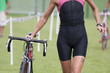 triathlète féminine avec son vélo en zone de transition