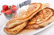stack of pancakes with syrup and fruit