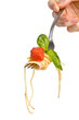 spaghetti with tomato sauce and basil hanging from a fork