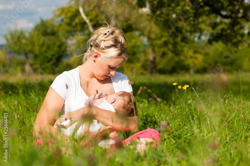 Foto: Mutter stillt Baby auf Wiese Mutter stillt Baby auf Wiese