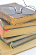 alte Bücher aufgestapelt und eine Lesebrille