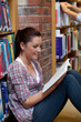 Pretty young woman reading a book sitting on the floor Pretty young woman reading a book sitting on the floor