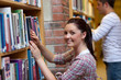 Joyful young woman looking for a book Joyful young woman looking for a book
