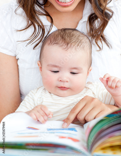 Photo: Bright mother showing images in a book to her cute little son Bright mother showing images in a book to her cute little son