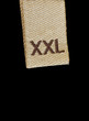 Macro of XXL size clothing label tag isolated on black