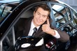 Portrait of man sitting in new car showing thumbs up