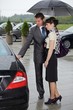 Young man opening door of car for woman