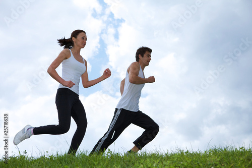 Photo: Young couple exercising in park Young couple exercising in park