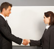Businessman and woman shaking hands in office, smiling