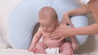 Mother helping baby sit up