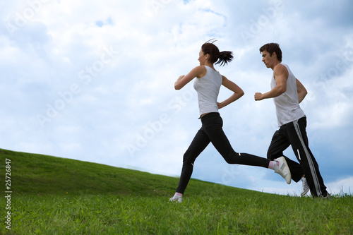 Photo: Young couple exercising in park Young couple exercising in park