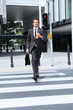 young caucasian businessman in park walking on red light on zebr