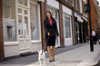 A businesswoman walking her dog in the street