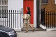 A businesswoman carrying her dry cleaning